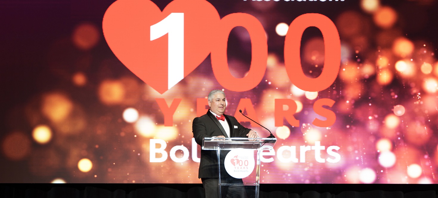 Speaker at podium in front of 100 years bold hearts logo